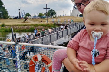 Eine Frau hält ihr Kleinkind auf dem Arm. Beide sind auf der Weserfähre Bremen.