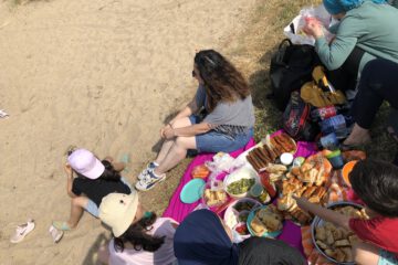 Familien machen ein Picknick am Sandstrand in der Überseestadt