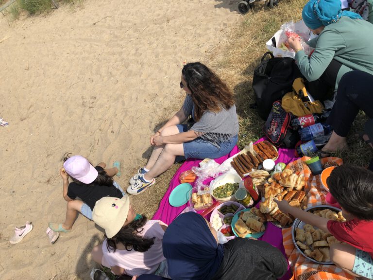 Familien machen ein Picknick am Sandstrand in der Überseestadt