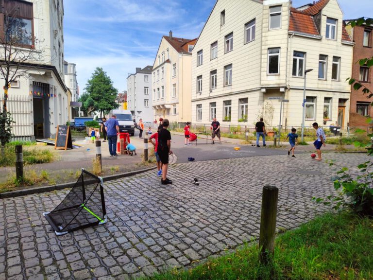Auf der Liegnitzstraße im Liegnitzquartier spielen Kinder auf der Straße. EIn paar Spielgeräte, wie ein kleines Fußballtor, sind aufgebaut.