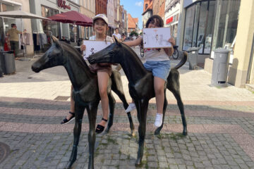 In der Fußgängerzone der Stadt Verden stehen zwei Bronzestatuen. Es sind zwei Fohlen. Zwei Mädchen posieren auf den Fohlen sitzend und zwigen ihre Skizzenbilder