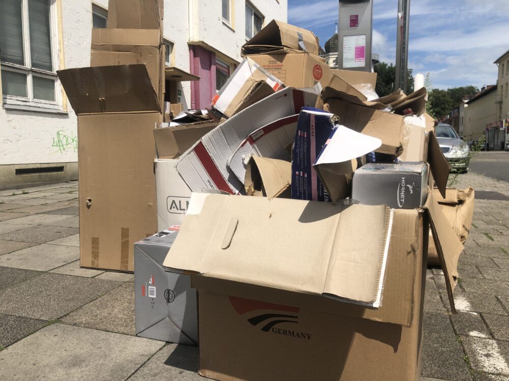 Ein großer Stapel Altpapier auf dem Bürgersteig wartet auf die Abholung.