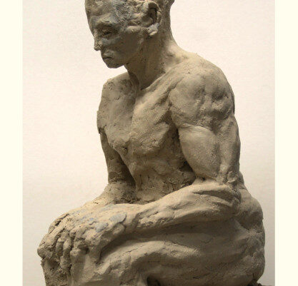 Eine Skulptur aus Ton von einer sitzenden Person in Seitenansicht.
