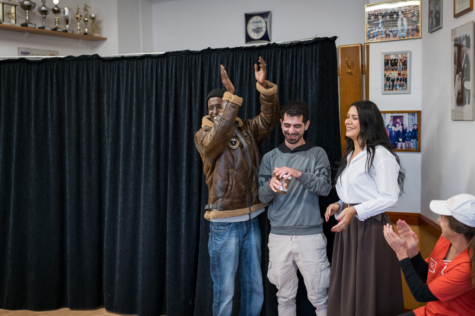 Drei Personen performen vor einem schwarzen Vorhang.