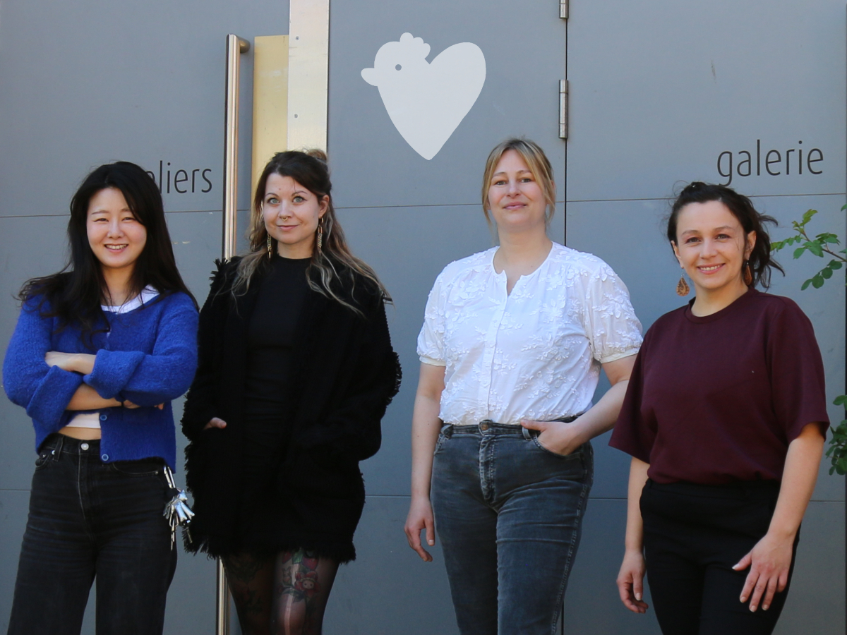 Vier Frauen stehen selbstbewußt vor einer großen Haustür an der steht: atelierhaus roter hahn"