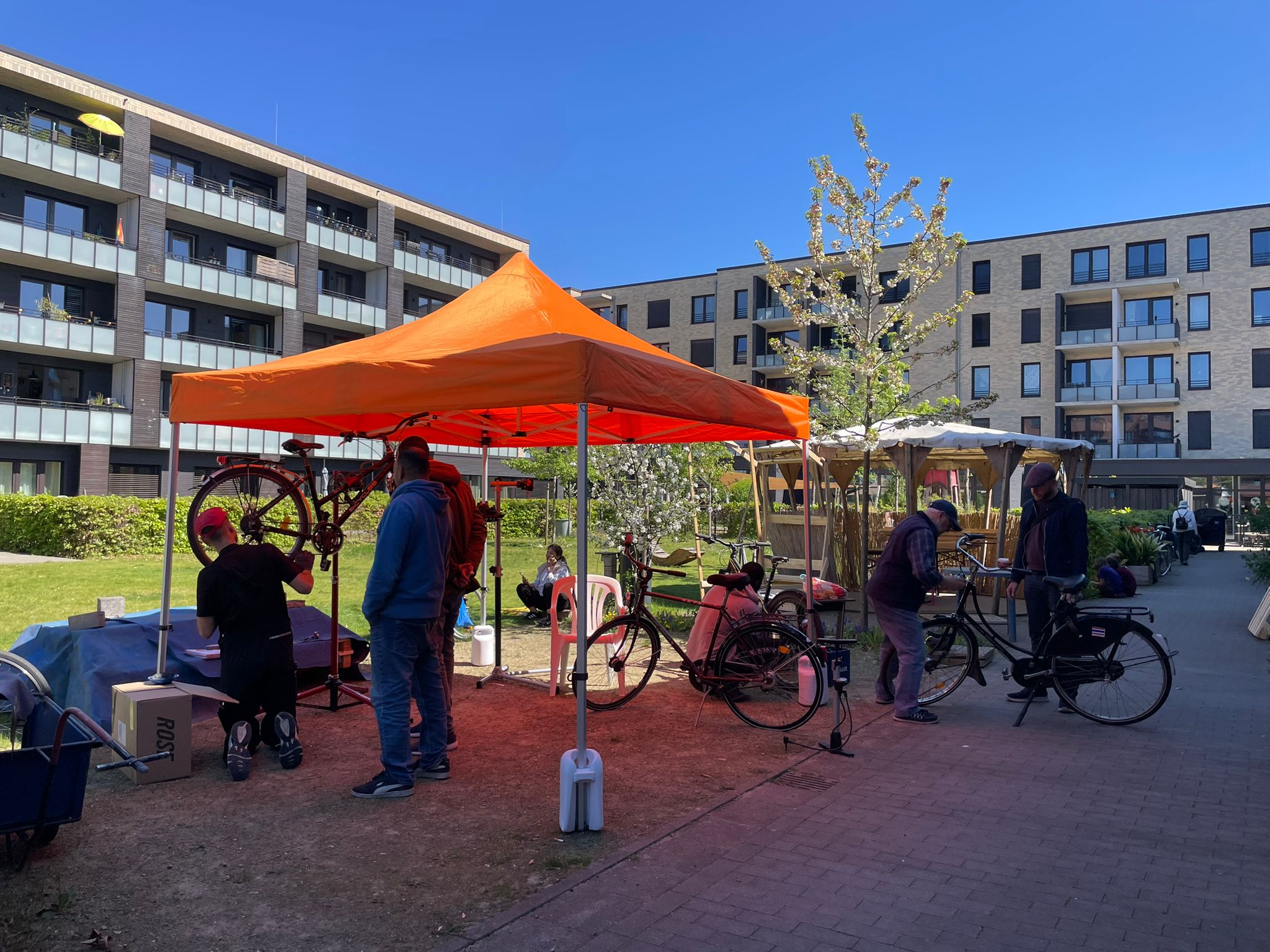 Eine Fahrradwerkstatt unter freiem Himmel. Unter einem Pavillon in einem Hinterhof werden Fahrräder repariert.