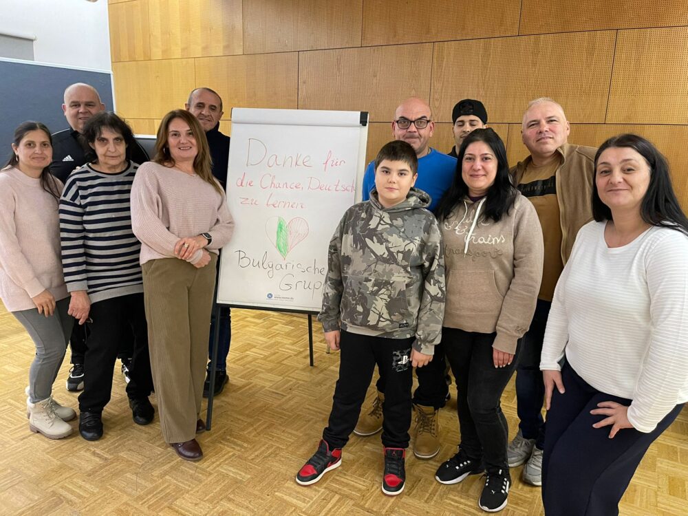 Eine Gruppe von Personen steht in einem Raum rund um ein Flipchart auf dem steht: "Danke für die Chance, Deutsch zu lernen". Ein Herz mit den Nationalfarben ist aufgemalt, darunter Bulgarische Gruppe.
