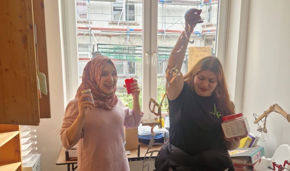 Zwei Jugendliche machen lustige Bewegungen bei einer Aufräumaktion. Ein Bild der guten Laune.