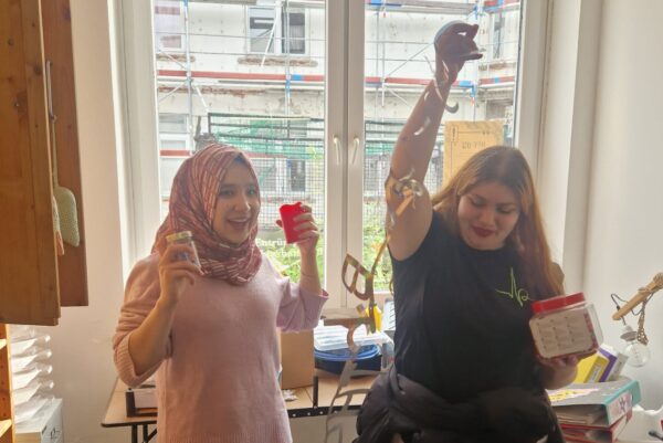 Zwei Jugendliche machen lustige Bewegungen bei einer Aufräumaktion. Ein Bild der guten Laune.