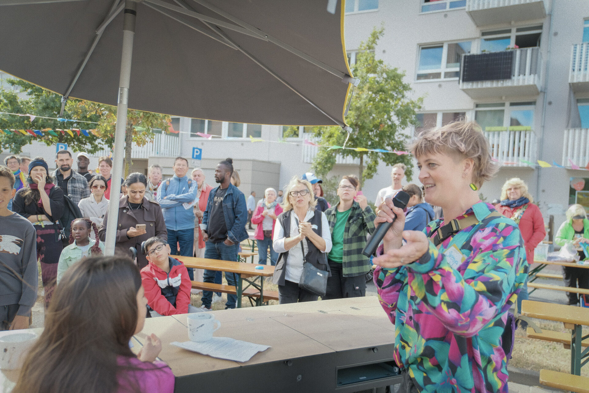 Svenja Weber spricht ins Mikrofon und schaut die Kinder neben ihr an.