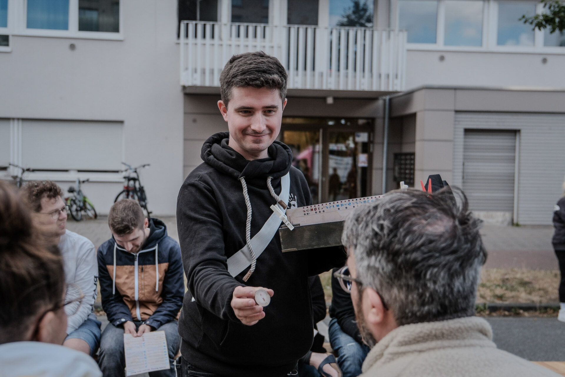 Dennis zeigt einem Mitspieler einen kleinen Coin.