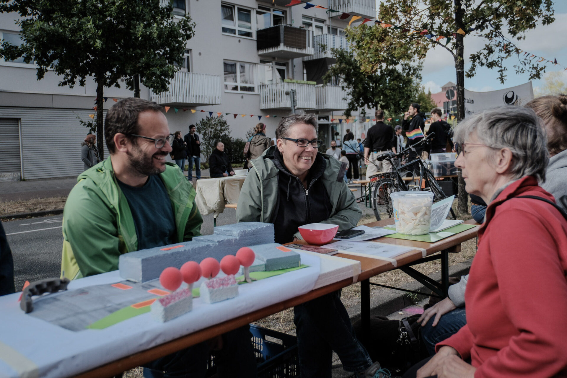 Drei Personen unterhalten sich am Tisch von dem Verein "Heimatviertel Waller Wied"