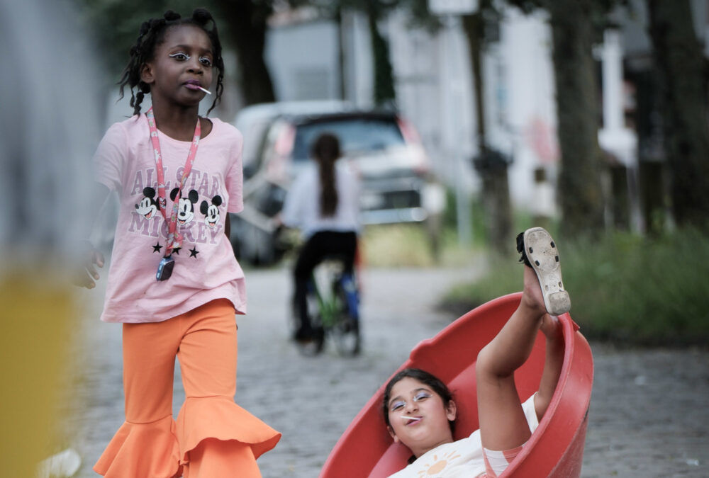 Auf einer Straße sind zwei vergnügt spielende Kinder