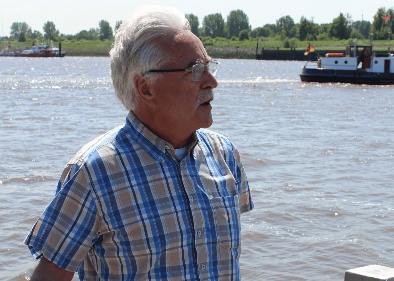 Portraitfoto von Dieter Stratmann, im hintergrund ein Wendebecken, ein Schiffanlager und dein Stück Schiff.