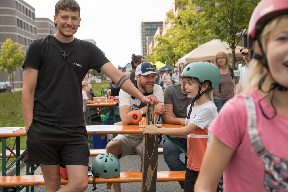 Tim vom Sportgarten zeigt Kindern wie man Skatet. 