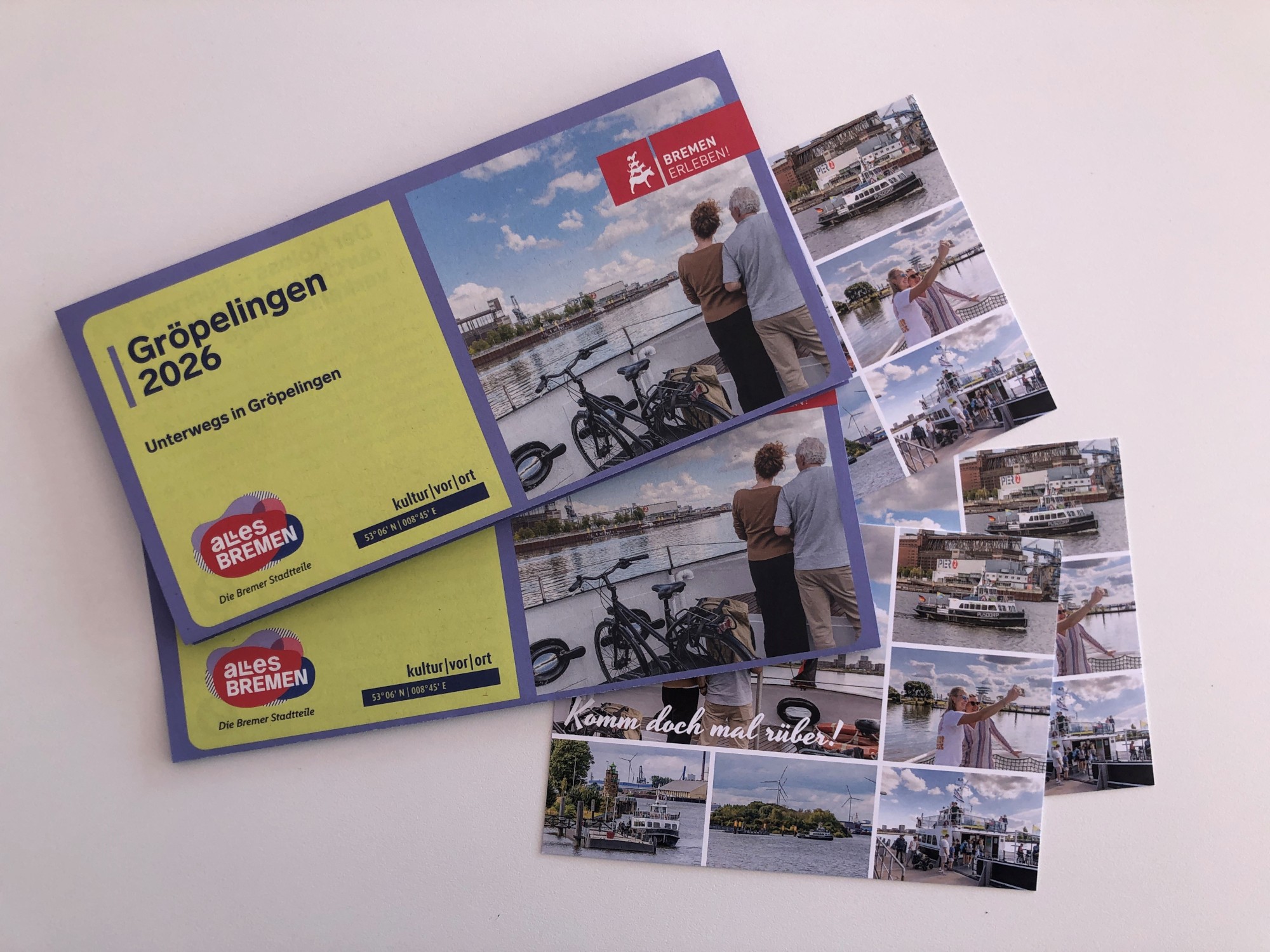 Mehrere Postkarten und Flyer leigen aufgefächert auf einem Tisch.