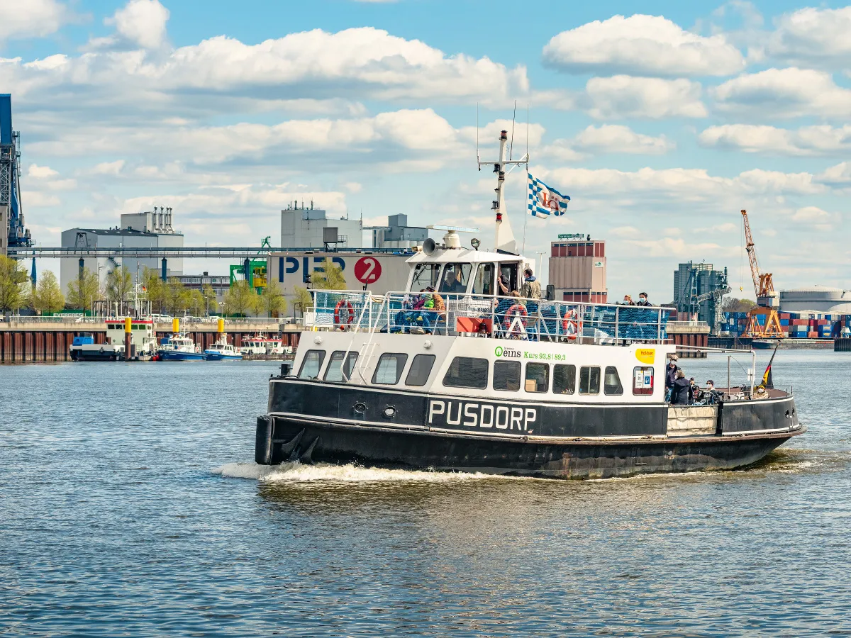 Auf dem Fluss Weser fährt das Fahrgastschiff Pusdorp. Im Hintergrund ist der Gröpelinger anleger Pier 2 / Waterfront zu sehen.